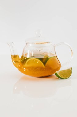 Beyaz arka planda cam çaydanlıkta çay