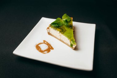 Beyaz tabakta kivili cheesecake.