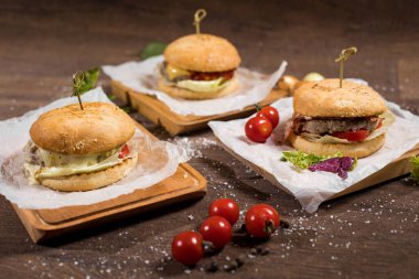 Lezzetli hamburgerler masada vişneli domateslerle yatıyor..