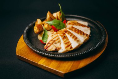 Tabakta kızarmış patatesle birlikte iştah açıcı et.