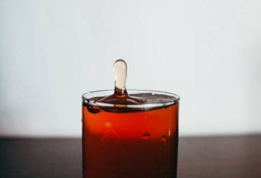 Bardağa biraz içki dökerek. 