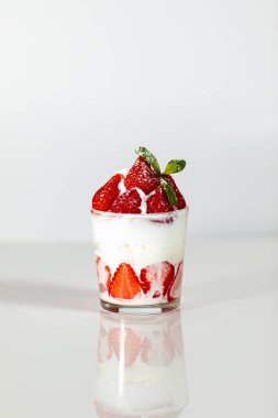 Beyaz arka planda bardakta tatlı.