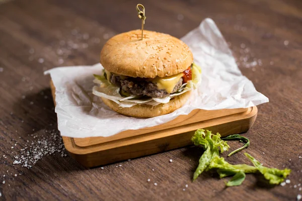 Tahta masadaki lezzetli burgerin yakın plan görüntüsü.