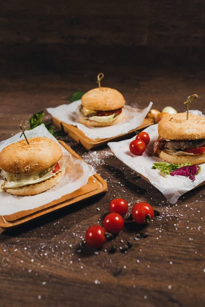 Deliciosas Hamburguesas Tumbadas Sobre Mesa Con Tomates Cherry —  Fotos de Stock