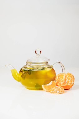 Beyaz arka planda cam çaydanlıkta çay