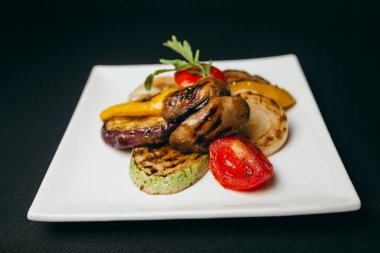 Karanlık masada nefis ızgara sebzeler.