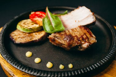 Arka planda sebzeli leziz ızgara et yemeği.