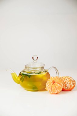 Beyaz arka planda cam çaydanlıkta çay
