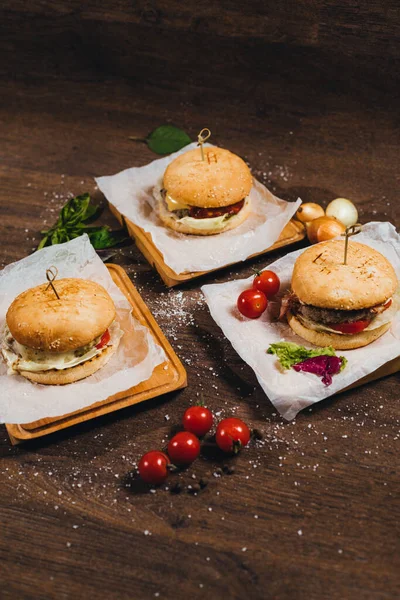 Deliciosas Hamburguesas Tumbadas Sobre Mesa Con Tomates Cherry —  Fotos de Stock