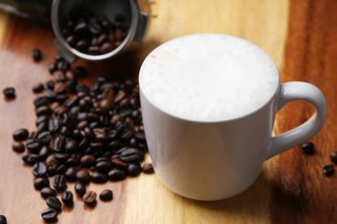 Sıcak latte, sıcak kahve ve ahşap zeminde süt köpüğü