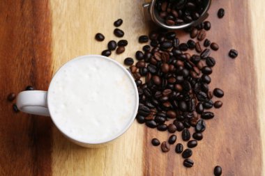 Sıcak latte, sıcak kahve ve ahşap zeminde süt köpüğü