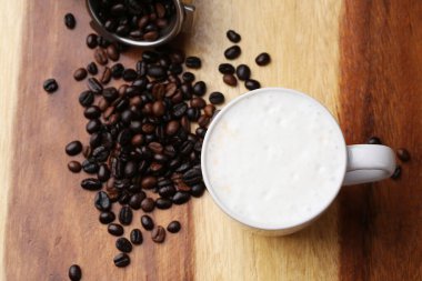 Sıcak latte, sıcak kahve ve ahşap zeminde süt köpüğü