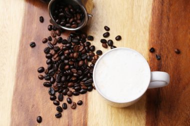 Sıcak latte, sıcak kahve ve ahşap zeminde süt köpüğü