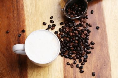 Sıcak latte, sıcak kahve ve ahşap zeminde süt köpüğü