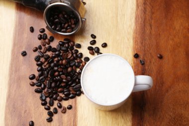 Sıcak latte, sıcak kahve ve ahşap zeminde süt köpüğü