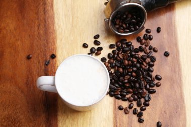 Sıcak latte, sıcak kahve ve ahşap zeminde süt köpüğü