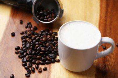 Sıcak latte, sıcak kahve ve ahşap zeminde süt köpüğü