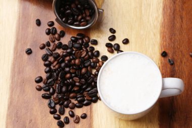 Sıcak latte, sıcak kahve ve ahşap zeminde süt köpüğü