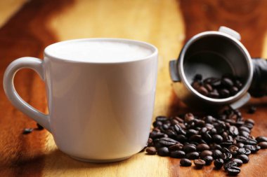 Sıcak latte, sıcak kahve ve ahşap zeminde süt köpüğü