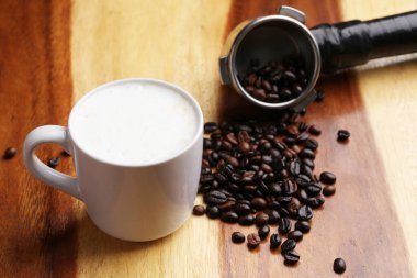 Sıcak latte, sıcak kahve ve ahşap zeminde süt köpüğü