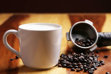 Sıcak latte, sıcak kahve ve ahşap zeminde süt köpüğü