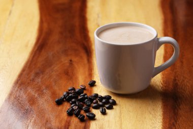 Sıcak latte, sıcak kahve ve ahşap zeminde süt köpüğü