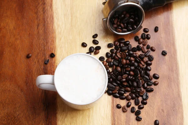 Sıcak latte, sıcak kahve ve ahşap zeminde süt köpüğü