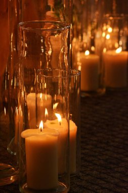 Karanlıkta katta sıcak bir ışık cam büyük mumlar yakın çekim