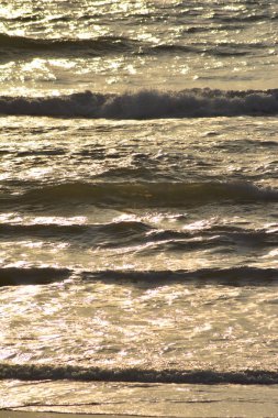 Buna ek olarak sıcak sarı, turuncu ve siyah renkleri tonlarını deniz pürüzsüz yüzey düz kontrast flacks güneş ışığı ile soyulmuş doku küçük dalgalar