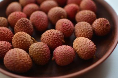 Kahverengi bir kil plaka üzerinde Olgun pembe lychee çilek yakın