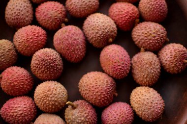 Kahverengi bir kil plaka üzerinde Olgun pembe lychee çilek yakın