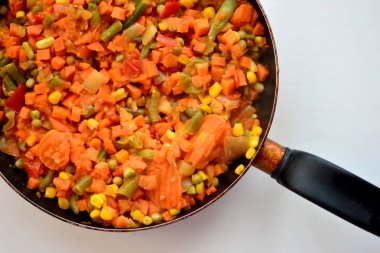 Pişmiş sebze karışımı kesilmiş ve dilimlenmiş mısır, havuç, bezelye, yeşil fasulye, sıcak bir tavada tatlı biber üst görünümü makro yakın malzemeler içeriyordu