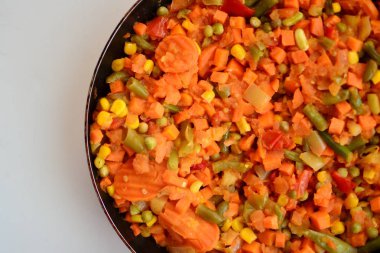 Pişmiş sebze karışımı kesilmiş ve dilimlenmiş mısır, havuç, bezelye, yeşil fasulye, sıcak bir tavada tatlı biber üst görünümü makro yakın malzemeler içeriyordu