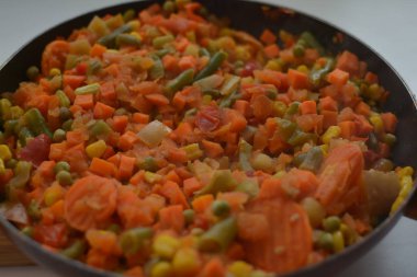 Pişmiş sebze karışımı kesilmiş ve dilimlenmiş mısır, havuç, bezelye, yeşil fasulye, sıcak bir tavada tatlı biber üst görünümü makro yakın malzemeler içeriyordu