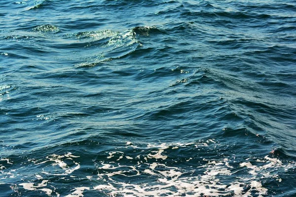 低波ハイライトと海泡の背景が豊かなアクアカラーでクローズアップ透明な青い海水面の波打つ抽象的なテクスチャ — ストック写真