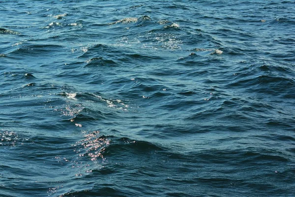 抽象纹理闪闪发光的波光粼粼的清澈的蓝色海水表面与低波突出背景特写与丰富的水彩 — 图库照片