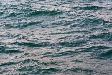 Zengin su renkleri ile düşük dalgalar arka plan ile dalgalanan berrak mavi okyanus su yüzeyinin soyut doku