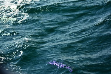 Düşük dalgalar vurgular ve deniz köpüğü arka plan zengin su renkleri ile yakın dalgalanan berrak mavi okyanus su yüzeyinin soyut doku