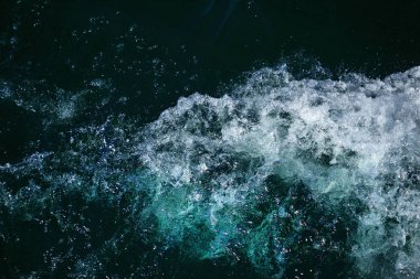 Düşük dalgalar ve deniz köpüğü arka plan ile dalgalanan berrak mavi okyanus koyu su yüzeyinin soyut doku zengin su renkleri ile yakın