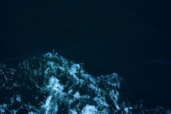低波と海泡の背景が豊かなアクアカラーでクローズアップ透明な青い海の暗い水面を波打つ抽象的なテクスチャ — ストック写真