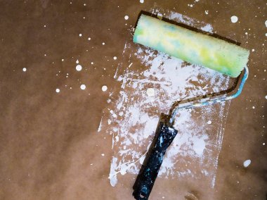 Bir sürü damla, sıçrama ve leke ile kraft kağıt üzerinde beyaz boya ile açık mavi, yeşil ve sarı boya rulo renkli üst görünüm arka plan