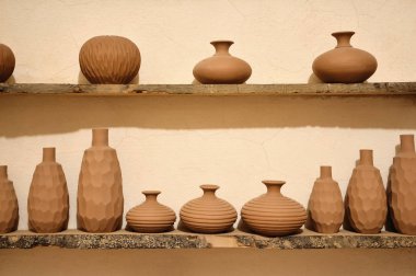 Arka arkaya dik ilen iki rafta doğal kilden yapılmış eşsiz el yapımı iz oryantal geleneksel çömlek vazoları