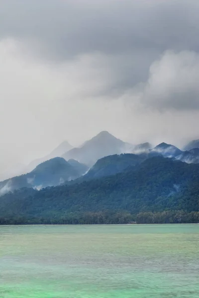 Regenachtige Misty Island Heuvels Hoge Bergen Door Kalme Zee Oppervlak Stockfoto