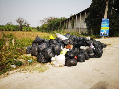 Chiangrai, Tayland - 12 Şubat: Yan yol üzerinde 12 Şubat 2019 Chiangrai, Tayland, patika üzerinde siyah çöp yığını.