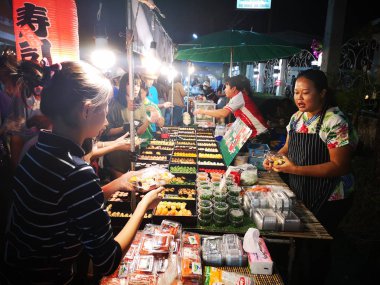 Chiang Rai, Tayland - 12 Haziran : Kimliği belirsiz kişiler 12 Haziran 2019'da Chiang rai, Tayland'da gece yürüyüş sokak pazarında suşi alıp satan lar.