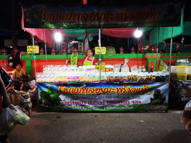Loei ,Tayland - 12 Haziran : Loei, Tayland'da 12 Haziran 2019 tarihinde gece yürüyüş sokak pazarında şeker kaplı hindistan cevizi satan tanımlanamayan Asyalı kadın.