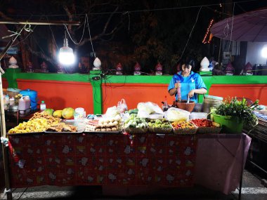 Loei ,Tayland - 12 Haziran : Loei, Tayland'da 12 Haziran 2019'da gece yürüyüş sokak pazarında papaya salatası satan tanımlanamayan Asyalı genç.