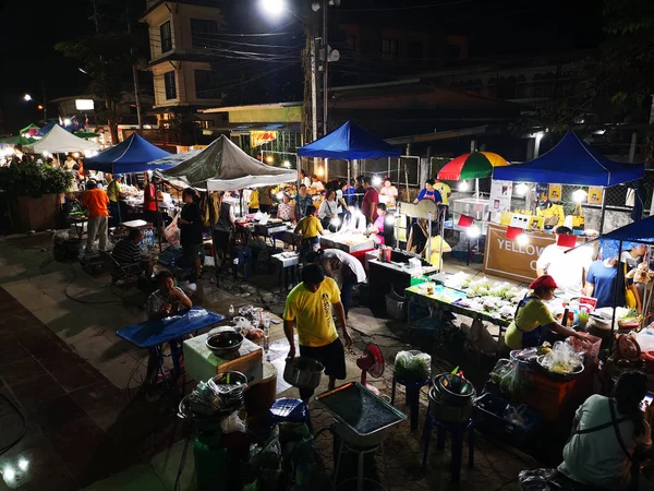 CHIANG RAI, TAILANDIA - 12 DE JUNIO: Personas no identificadas comprando y vendiendo bienes en el mercado callejero nocturno a pie el 12 de junio de 2019 en Chiang rai, Tailandia . —  Fotos de Stock