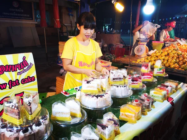 CHIANG RAI, THAILANDIA - 12 GIUGNO: Pwoman non identificata che vende torte a basso contenuto di grassi nel mercato notturno di strada a piedi il 12 giugno 2019 a Chiang rai, Thailandia . — Foto Stock