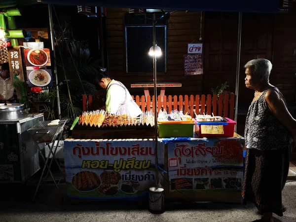 LOEI, THAILAND - JUNE 12: Unidentified asian woman selling grilled shrimp in night walking street market on June 12, 2019 in Loei, Thailand — стоковое фото